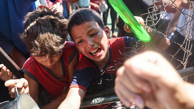 Palestinians gather to receive food from a charity kitchen, amid a hunger crisis, in Nuseirat 